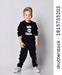 Small photo of Frolic strong blond kid boy in black jersey sweater with printed words inscription on it and rolled up sleeves. Translation: "Want. Can. Will Do"
