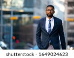 Small photo of Handsome charming cheerful african american businessman in swanky modern stylish suit and tie, colorful, classy, office building