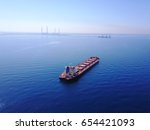 a bulk ship outside the port on a bog power station and its dock background