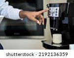 Small photo of Male hand using modern coffee machine in the morning making coffee at home or in office. Business man or barista brewing espresso coffee beverage in cup using coffeemaker. Close up view
