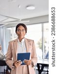 Small photo of Confident African American business woman manager standing at office team meeting. Portrait of elegant smiling professional female company executive leader holding digital tab in board room. Vertical.