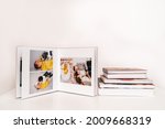on white table open photobook from photo shoot of family with newborn baby. preservation of important moments of life in photo album. result of work of photographer and designer. polygraphy.