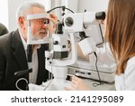 Small photo of ophthalmologist examination of elderly man with slit lamp. microscope and focused light source. device for high-precision examination of eye to determine condition of lens, cornea. medical equipment.