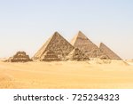 Giza pyramids in Cairo, Egypt. General view of pyramids from the Giza Plateau Three pyramids known as Queens' Pyramids on front side. Next in order from left, the Pyramid of Menkaure, Khafre and Chufu