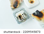 Small photo of Electrical short circuit. Failure caused by burning wire and rosettes melted plug in house. Electrical appliances ignition. Burnt socket and circuit breaker due to shortcut circuit. Safety regulations