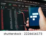 Small photo of Man holding phone with FTX logo. Global fall of cryptocurrency graph - FTT token fell down on the chart crypto exchanges on app screen. FTX exchange bankruptcy and the collapse depreciation of token