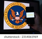 Small photo of Kyiv, Ukraine - 06 June 2023: Man holds a smartphone with crypto exchange Binance on screen against the background of monitor with the SEC logo. S.E.C. sued on Binance through money laundering in BNB