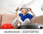 Small photo of Mischievous preschooler boy play the music using kitchen tools and utensils at home during quarantine. Funny drum part from child. Entertainment a little kids at home.