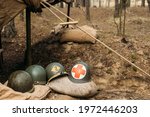 Metal Helmets Of United States Army Infantry Soldier At World War II. Helmets Near Camping Tent In Forest Camp.