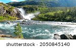 Small photo of Kinsarvik, Hordaland, Norway. Waterfall Nykkjesoyfossen In Hardangervidda Mountain Plateau. Spring Sunny Day. Height Of 49 m. Famous Norwegian Landmark And Popular Destination. Panorama