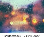 Drops Of Rain On Blue Glass Background. Street  Bokeh Lights Out Of Focus. Autumn Abstract Backdrop