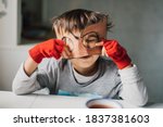 Small photo of Cute kid in disguise with DIY cardboard superhero mask at home. Boy with creative Halloween costume or festive apparel for children theater. Playful spirit concept. Home celebration with family.