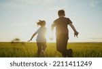 Small photo of boy girl a running in the park. happy family kid dream holiday concept. children hold hands brother sister run across the field silhouette summer in the park. kids sun run