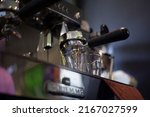 Small photo of Professional espresso maker ready to use. Espresso coffee pouring from espresso machine. Barista details in cafe. Espresso Preparation.