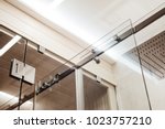 Small photo of Closer metal structure of the upper fasteners and rollers for the sliding glass door in the shower enclosure conjugated with the glass door to the sauna view in the interior
