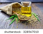 Flour hemp in a wooden spoon, seed in a bag and on the table, oil in a glass jar, cannabis leaves on the background of wooden boards