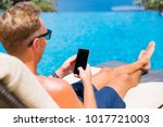 Man using smartphone by the pool.