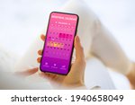 Woman tracking periods by using menstrual calendar app on phone
