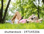 Young woman listening to music while lying down on grass
