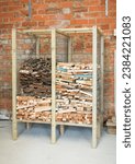 Small photo of Wooden rack for storing kindling, kindling storage inside a garage, UK