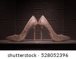 Gold elegant jewel encrusted wedding shoes against contemporary wallpaper background