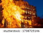 Small photo of Burning wooden buildings close-up. Raging flames of fire. Firestorm closeup. Building is on fire. Bright inferno flames. Hell fire. Burning constructions background. Intense combustion and heat.