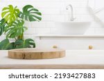 Round wooden podium for product display on blurred bathroom background