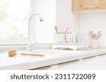 Eco-friendly cleaning brush on kitchen sink and drying dishes background