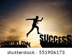 Businessman or worker jumping from Comfort zone to be Success. Business concept with sunset background.
