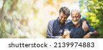 Small photo of senior father with adult son in family concept banner background with copy space, elderly old man person are happy and enjoy with hipster son together by walking outdoor in nature