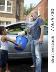 Small photo of Father and son washing a car horseplay splashing