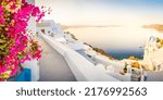 Small photo of street of traditional greek village Oia of Santorini, with blue domes, sunshine and flowers against Aegan sea and caldera, Greece