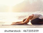 Beautiful woman practicing Yoga by the lake - Sun salutation series - Balasana or child's position - Toned image