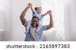 Small photo of Happy black African American father daughter playing at home living room. Afro man carry piggyback little toddler girl. Cheerful family bonding together father’s day concept banner with copy space