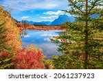 Indian summer in the Rocky Mountains of Canada. Red, yellow and orange foliage  on the shores of the Lake Vermillon. Mountains and lakes in autumnal gold foliage. 
