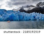 Gray Glacier is a blue glacier in Patagonia, Chile. Boat with tourists floats among icebergs. Huge iceberg has broken off from the Gray Glacier and drifts across the lake. Great Ice of Gray. 