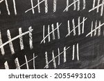 Small photo of Drawing counting tally chart with chalk, marks in groups of five, counting days