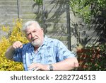 Small photo of Elderly or senior angry man with a clenched fist and about to strike or punch. Annoyed and has lost his temper and become violent.
