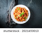Small photo of Hot pene bolognese with parmesan and basil. Italian cuisine. Fresh pasta with sauce.