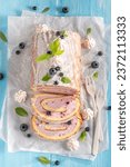 Small photo of Sweet blueberry swiss roulade as spring cake. Swiss roll made of berries and cream.