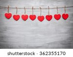 Love concept. Hearts hanging on a string, shot on grey background