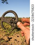 Small photo of an antique gold ring in the hand of a searcher, found on an old tract with the help of a metal detector, the foreground and background are blurred with a bokeh effect