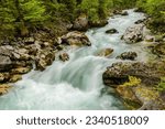 huge rocks in a fast flowing torrent during hiking in upper austria