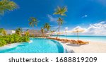 Panoramic holiday landscape. Luxurious beach resort hotel swimming pool and beach chairs or loungers under umbrellas with palm trees, blue sunny sky. Summer island seaside, travel vacation background