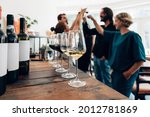 people inside a bar chilling out with a drink - friends talking and drinking in a winery - Millennials toasting at a wine tasting