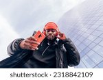 Small photo of cool street style hypebeast hip hop rapper influencer recording music video using cell phone
