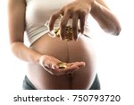 Small photo of Close up of young pregnant woman shaking piggy bank glass for golden coin money dropping to her hand - extravagant, prodigal, profligate, squandering, lavish, finance, fund and investment concept