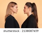 Two business woman facing each other face to face eyes to eyes friends business competition with partner concept. 2 caucasian female business person looking each other in face. Coworker confrontation