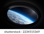 Small photo of Earth in spaceship international space station porthole. Travel and tourists in space, concept. Science fiction art. Elements of this image furnished by NASA.