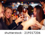 beautiful women clinking glasses in limousine. focus on glasses